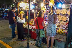 Mensen bekijken een kraampje op de Nightbazaar in Chiang Mai