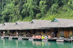 Mensen relaxen bij de drijvende huisjes van het Praiwan Raft House