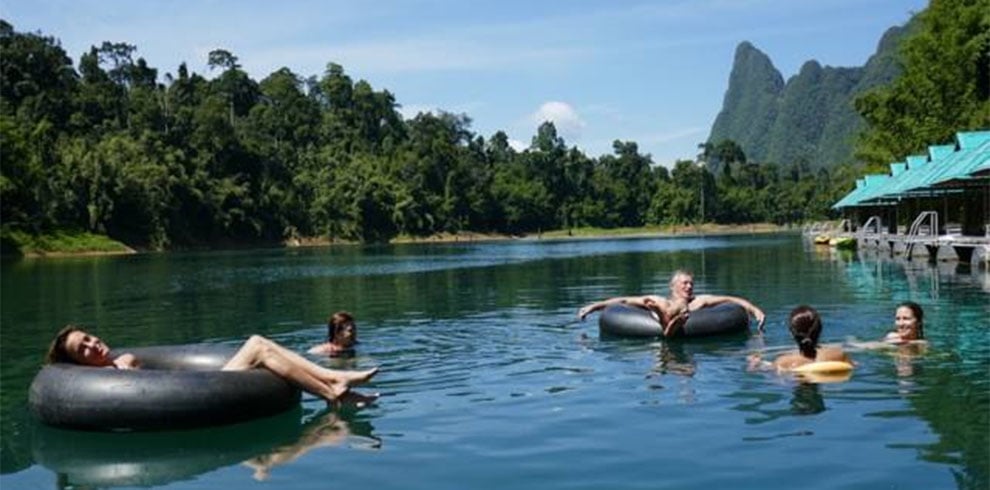 Mensen genieten in het water bij de Praiwan Raft Houses in Khao Sok