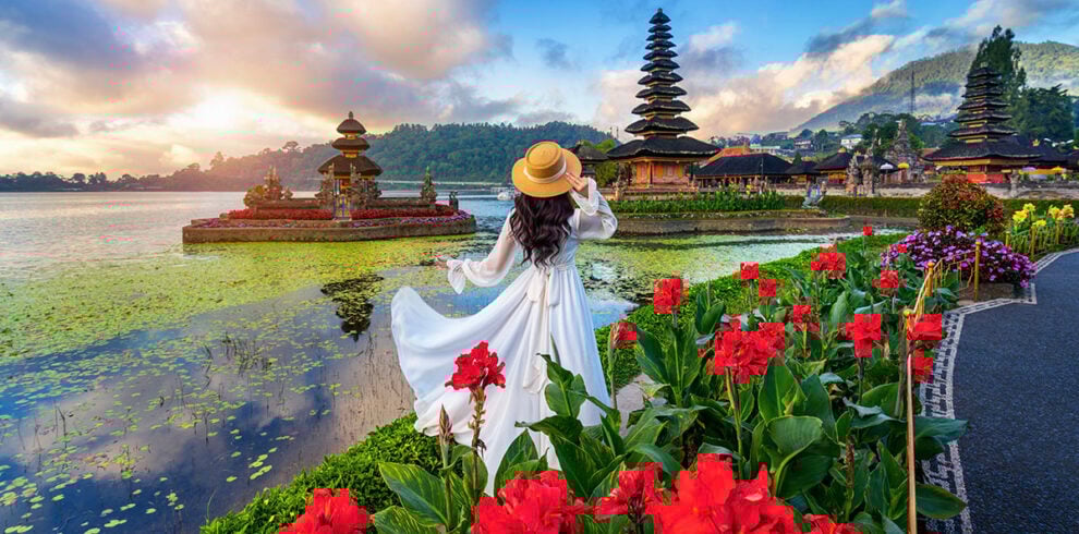 Vrouw kijkt uit over de Pura Ulun Danu tempel op Bali