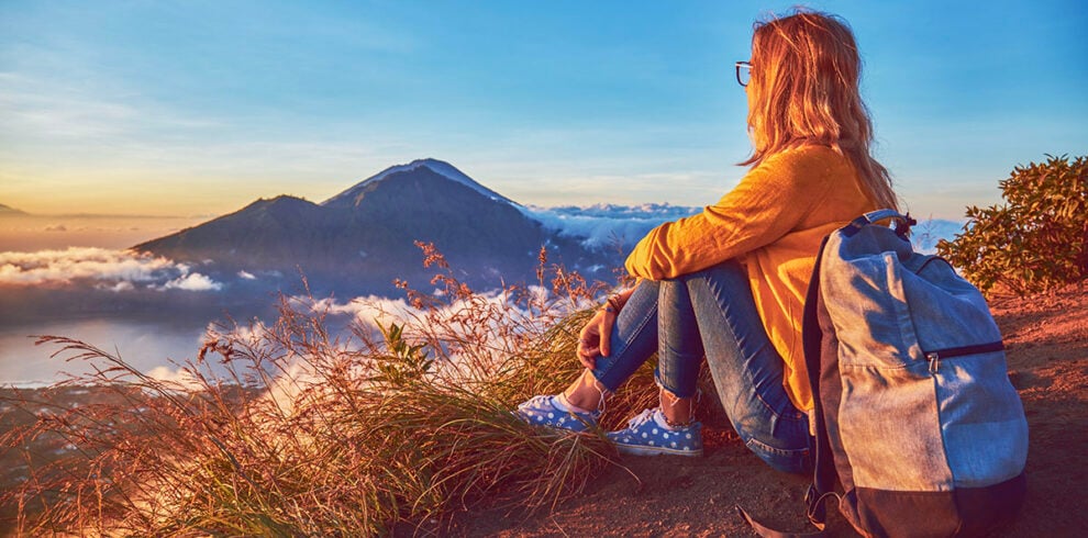 Vrouw geniet van de zonsopkomst vanaf Mount Batur in Bali