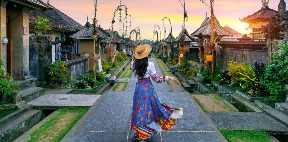 Vrouw loopt door het traditionele dorp Penglipran op Bali