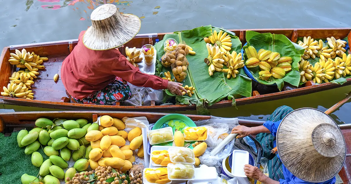 Dagtrips Thailand – drijvende markt met kleurrijk fruit en boten op het water