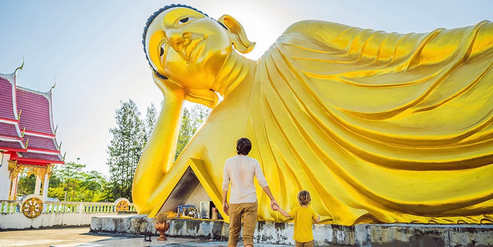 Vader en zoon bij een liggende Boeddha in Bangkok