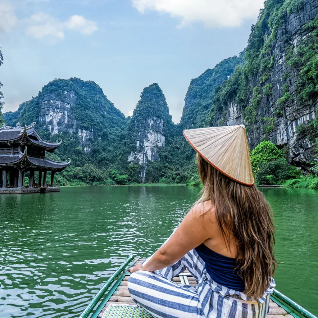 Boottocht door het landschap van Ninh Binh in Vietnam met kalkstenen rotsen en groene rivier