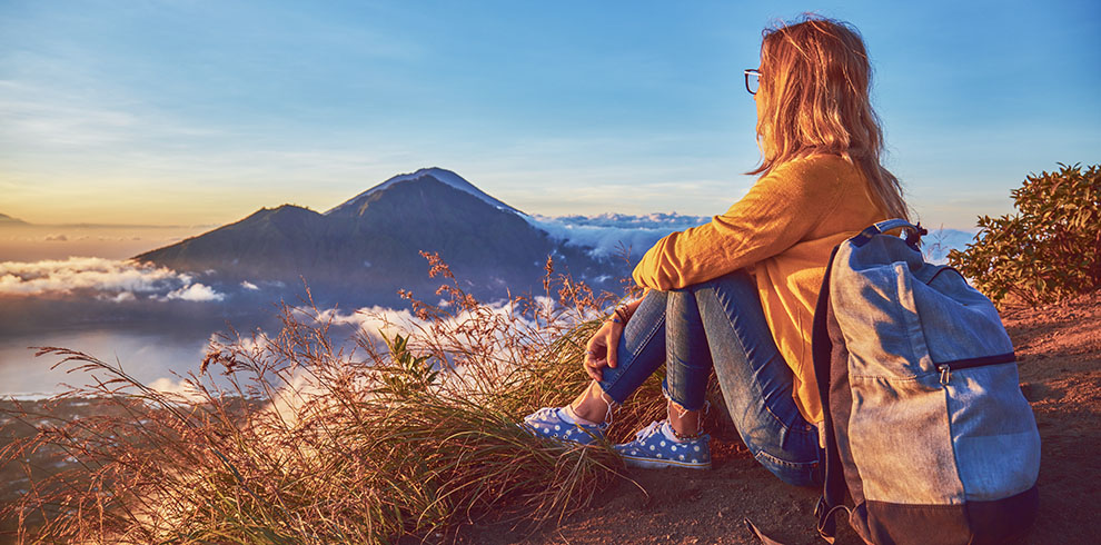 Vrouw geniet van het landschap en de zonsopkomst op de Batur vulkaan, Bali