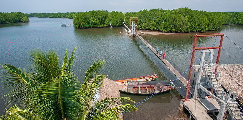 Groep toeristen wandelen over de hangbrug op Koh Kong, Cambodja