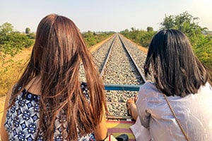 Twee vrouwen maken een tocht met de bamboetrein in Battambang, Cambodja