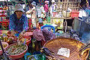 Een verkoper van lokaal voedsel op de markt in Phnom Penh, Cambodja