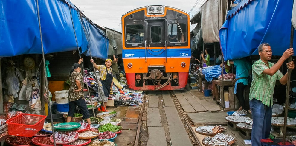 De trein rijdt over de Maeklong markt heen