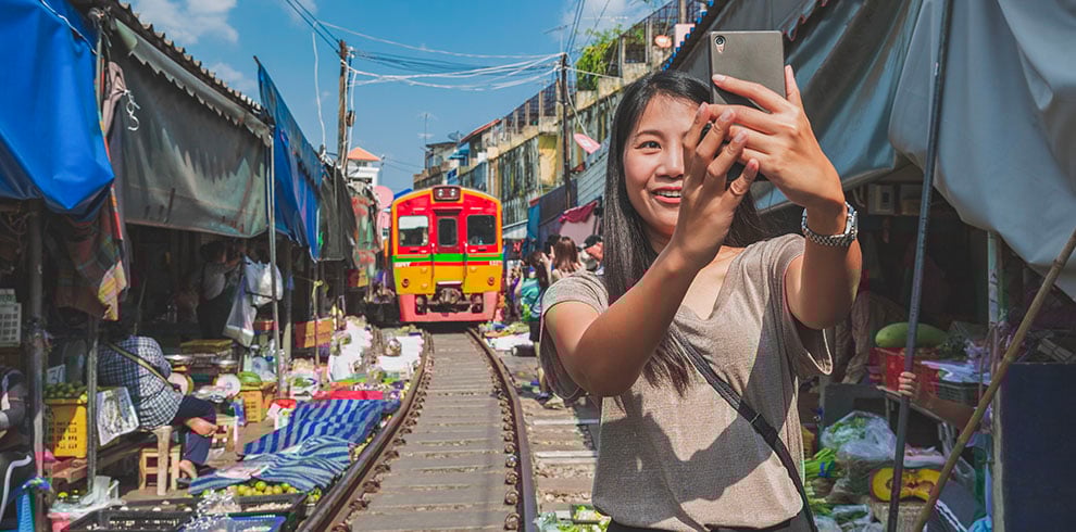 Vrouw maakt selfie op de Maeklong Trein Markt