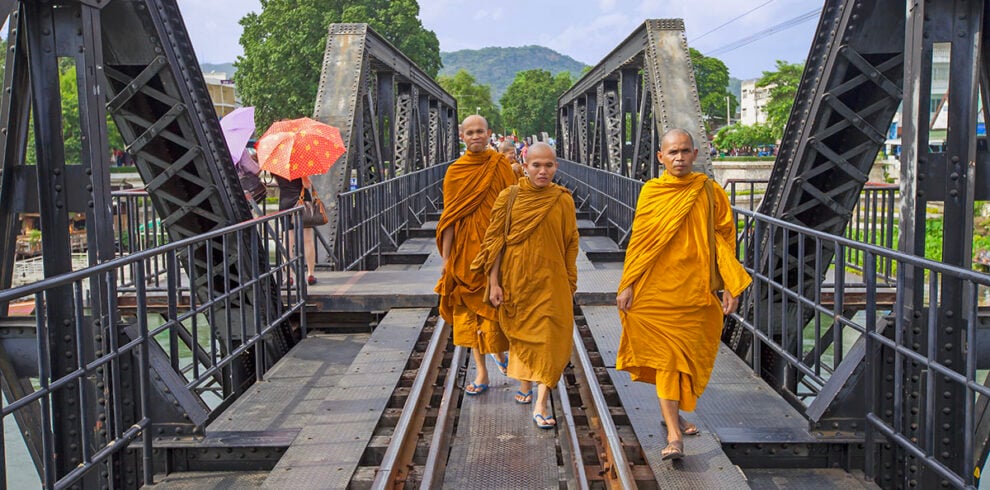 Drie monniken lopen over de River Kwai brug