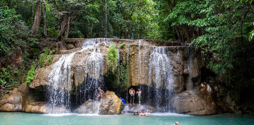 Mensen genieten bij de Erawan watervallen in Kanchanaburi, Thailand
