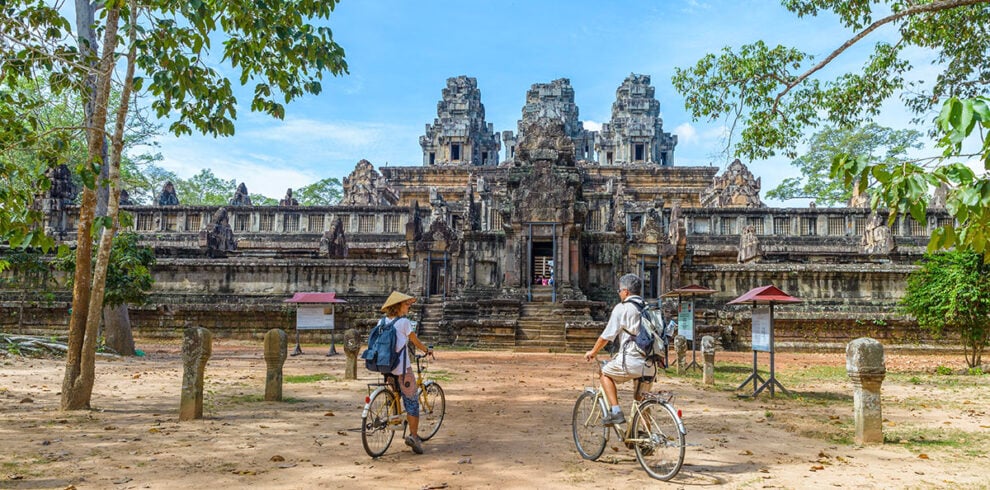 Toeristen fietsen bij de Angkor tempels in Cambodja