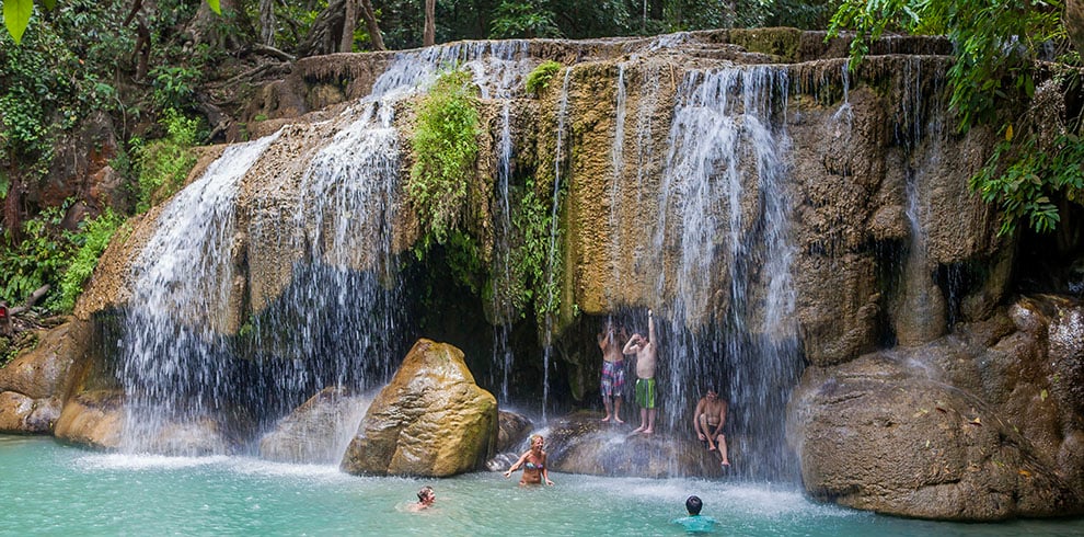 Toeristen zwemmen en relaxen bij de Erawan watervallen in Kanchanaburi