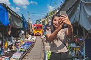 Vrouw maakt selfie op de Mae klong railway market in Thailand
