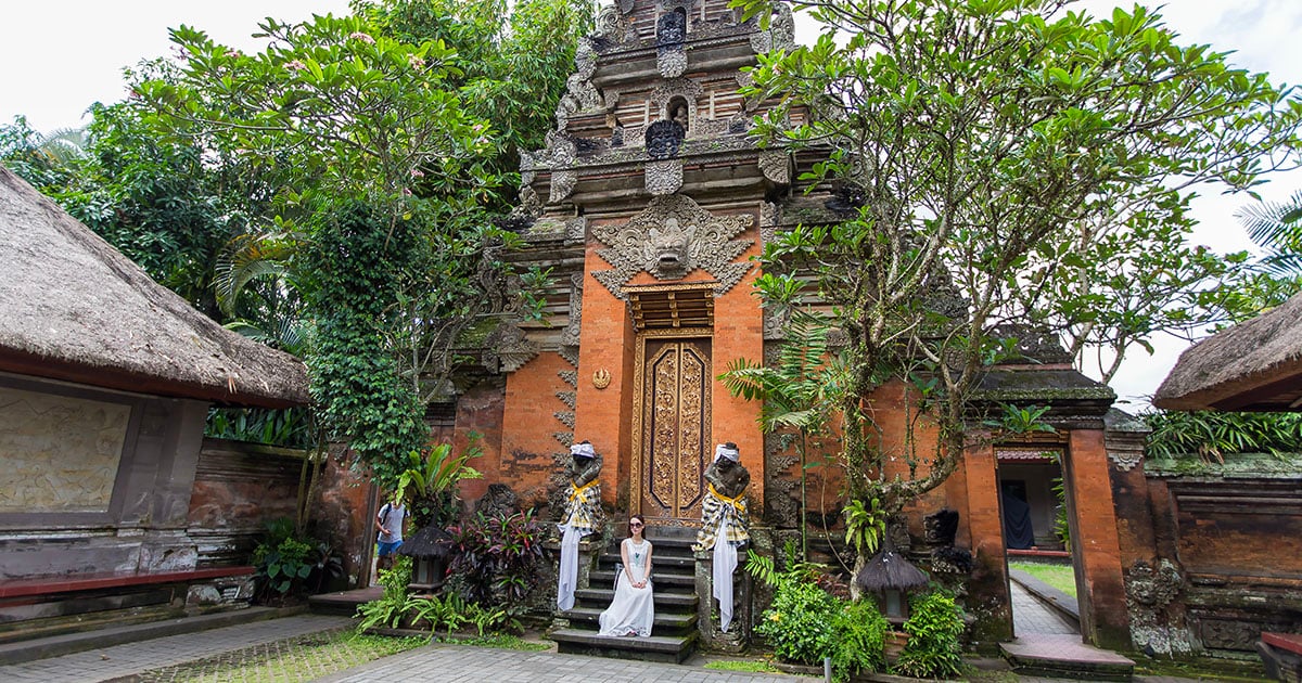 Jonge vrouw poseert bij de Pura Saran Agung in Ubud, Bali