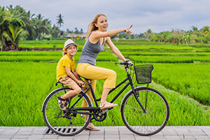 Moeder en zoon fietsen door de rijstvelden bij Ubud, Bali