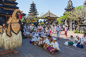 Gelovigen bidden en brengen offers in de Goa Lawah tempel op Bali
