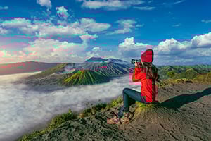 Toerist maakt een foto van de zonsopkomst boven Mount Bromo op Java