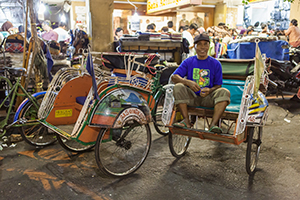 Riksja in de straten van Yogyakarta in de avonduren