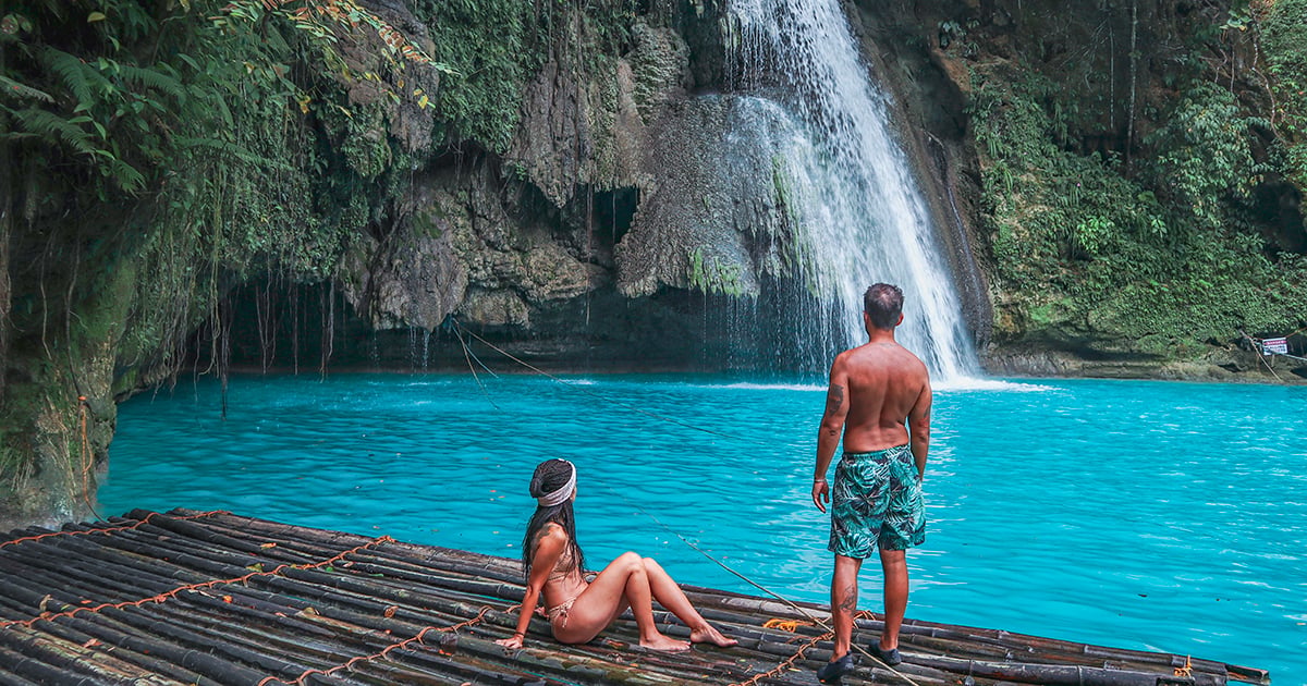 Bamboevlot met toeristen bij het helderblauwe water van Kawasan Falls in Badian, Filipijnen.
