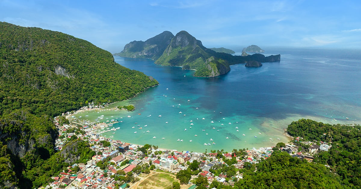 Luchtfoto van El Nido Town op Palawan met traditionele Filipijnse bangka-boten in het kristalheldere water van Bacuit Bay.