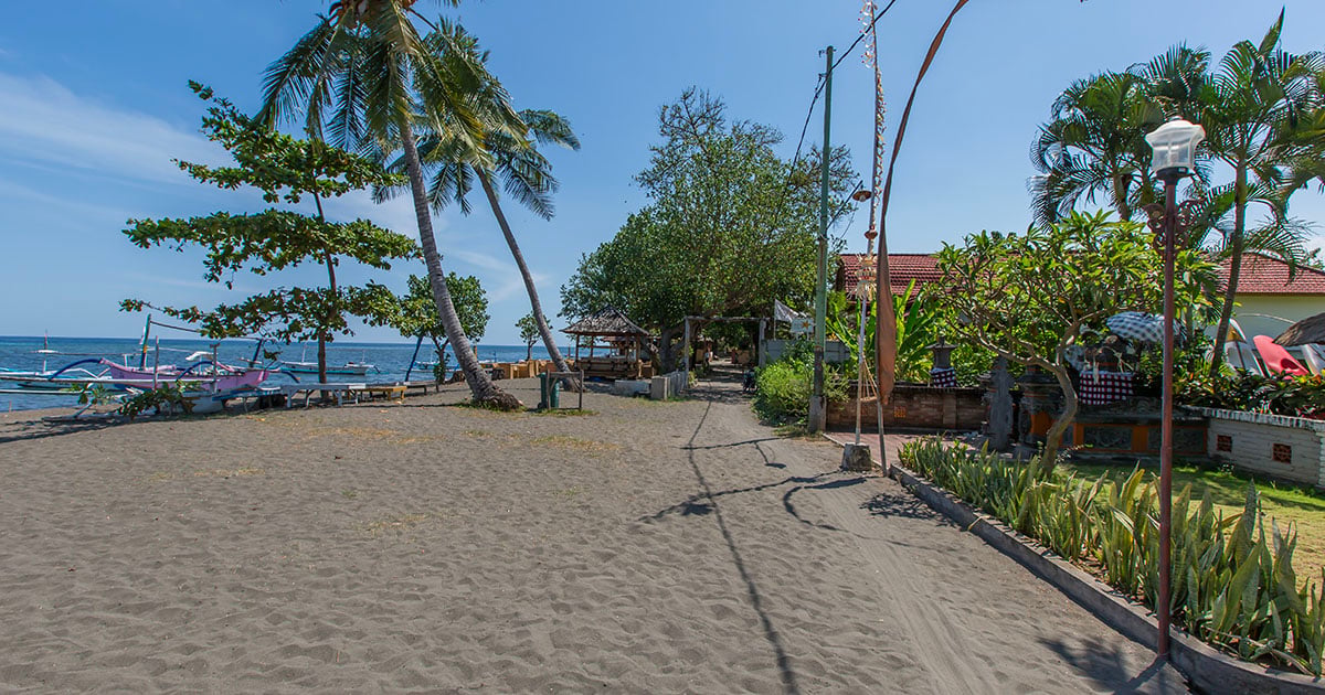 Rustig zwart zandstrand aan de kust van Lovina, Bali.