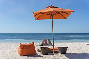 Zitzak en parasol op een tropisch strand met uitzicht op de zee.