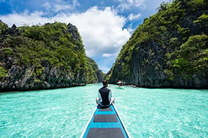 Een man zit op een boot tijdens de Island Hopping Tour in El Nido, Filipijnen