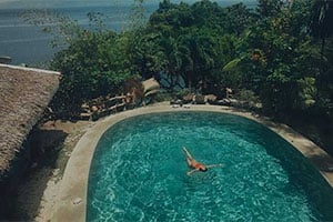 Het tropische zwembad van Fantasy Lodge in Samboan, omgeven door palmbomen, weelderige tuinen en comfortabele ligbedden voor een ontspannen verblijf aan de zuidkust van Cebu.