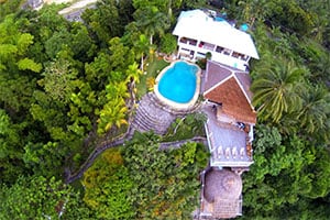 Luchtfoto van Fantasy Lodge in Samboan, een kleinschalige accommodatie omringd door tropisch groen, met zwembad en uitzicht op de kust van Zuid-Cebu.