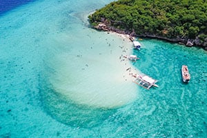 Luchtfoto van de iconische zandbank op Sumilon Island, omringd door turquoise water, witte stranden en een tropisch landschap aan de zuidkust van Cebu.