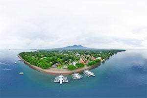 Luchtfoto van het Pura Vida Beach and Dive Resort in Dauin, met tropische tuinen, zwembad en directe ligging aan de kust van Negros Oriental.