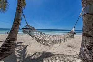 Een hangmat onder palmbomen bij White Beach op Bohol.