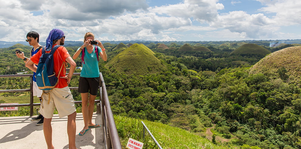 Toeristen maken foto's vanaf het viewpoint bij de Chocolate Hills op Bohol
