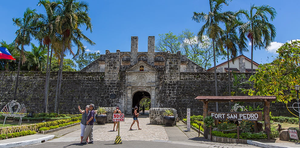 Toeristen maken een selfie bij Fort San Pedro op Cebu, Filipijnen