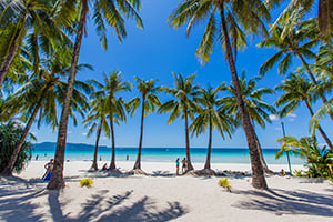 Toeristen onder de palmbomen van White Beach op Boracay, Filipijnen