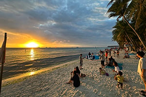 Toeristen genieten op het strand van Boracay van de zonsondergang