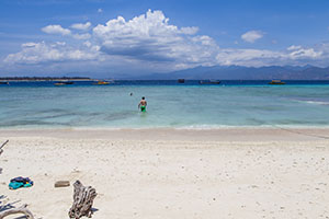 Man loopt de zee in op een rustig strand op Gili Trawangan