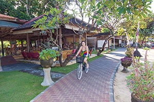 Vrouw fietst langs het strand bij Sanur op Bali