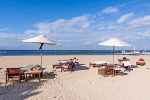 Toeristen genieten op het strand van Sanur op Bali