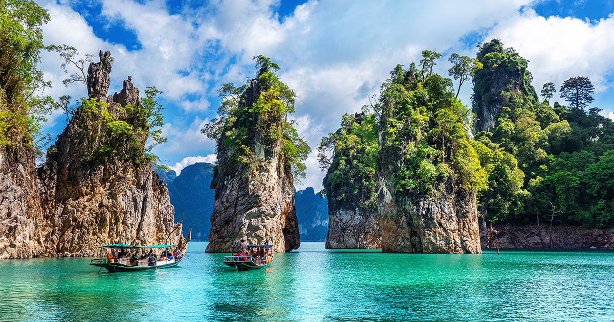 Karstbergen rijzen spectaculair op uit het smaragdgroene water van Khao Sok National Park in Thailand.