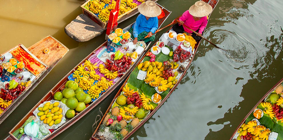 Kleurrijke bootjes met tropisch fruit op de drijvende markt van Damnoen Saduak