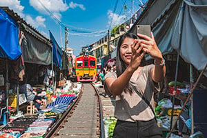Reiziger maakt een selfie op de Mae Klong Treinmarkt in Thailand