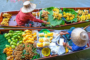 Kleurrijke bootjes vol tropisch fruit op de drijvende markt van Damnoen Saduak in Thailand