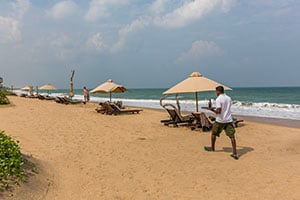 Personeel komt een koel drankje brengen op het strand bij het Pigeon Island Beach Resort in Nilaveli
