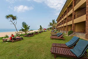Toeristen op ligbedden bij het Koggala Beach Resort met uitzicht op de zee.